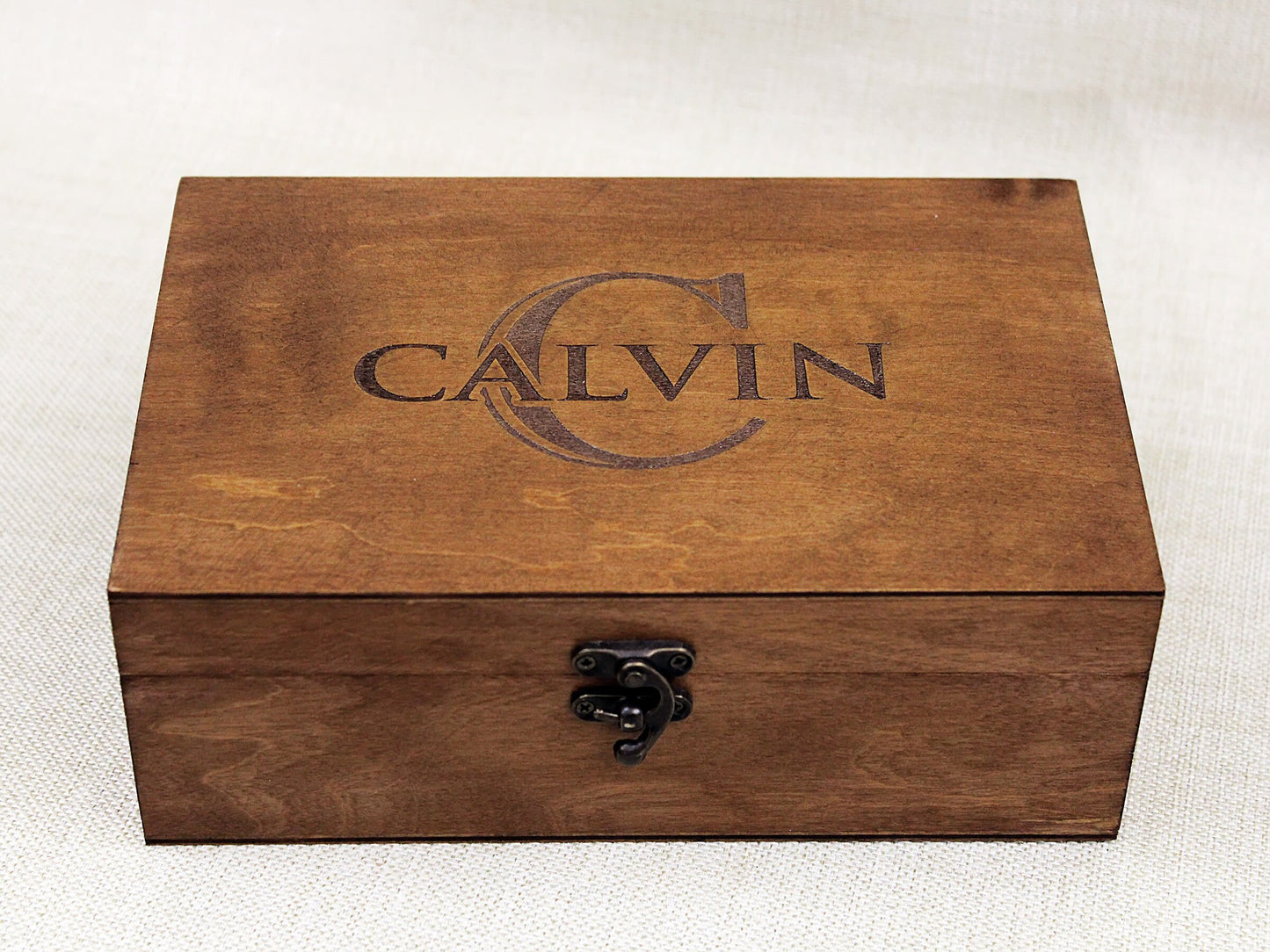 Close-up of engraved wooden box showing detailed name and monogram personalization on lid
