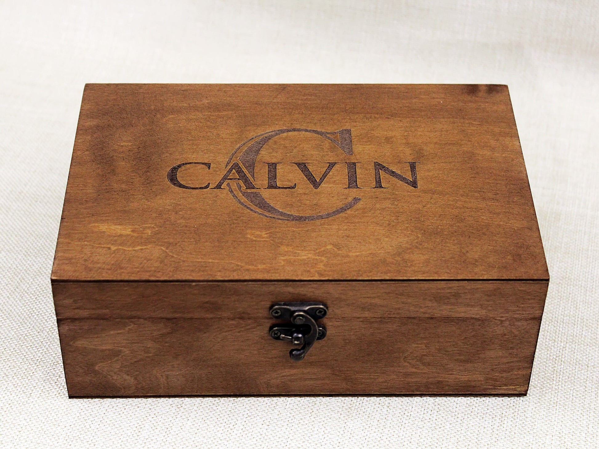 Close-up of engraved wooden box showing detailed name and monogram personalization on lid