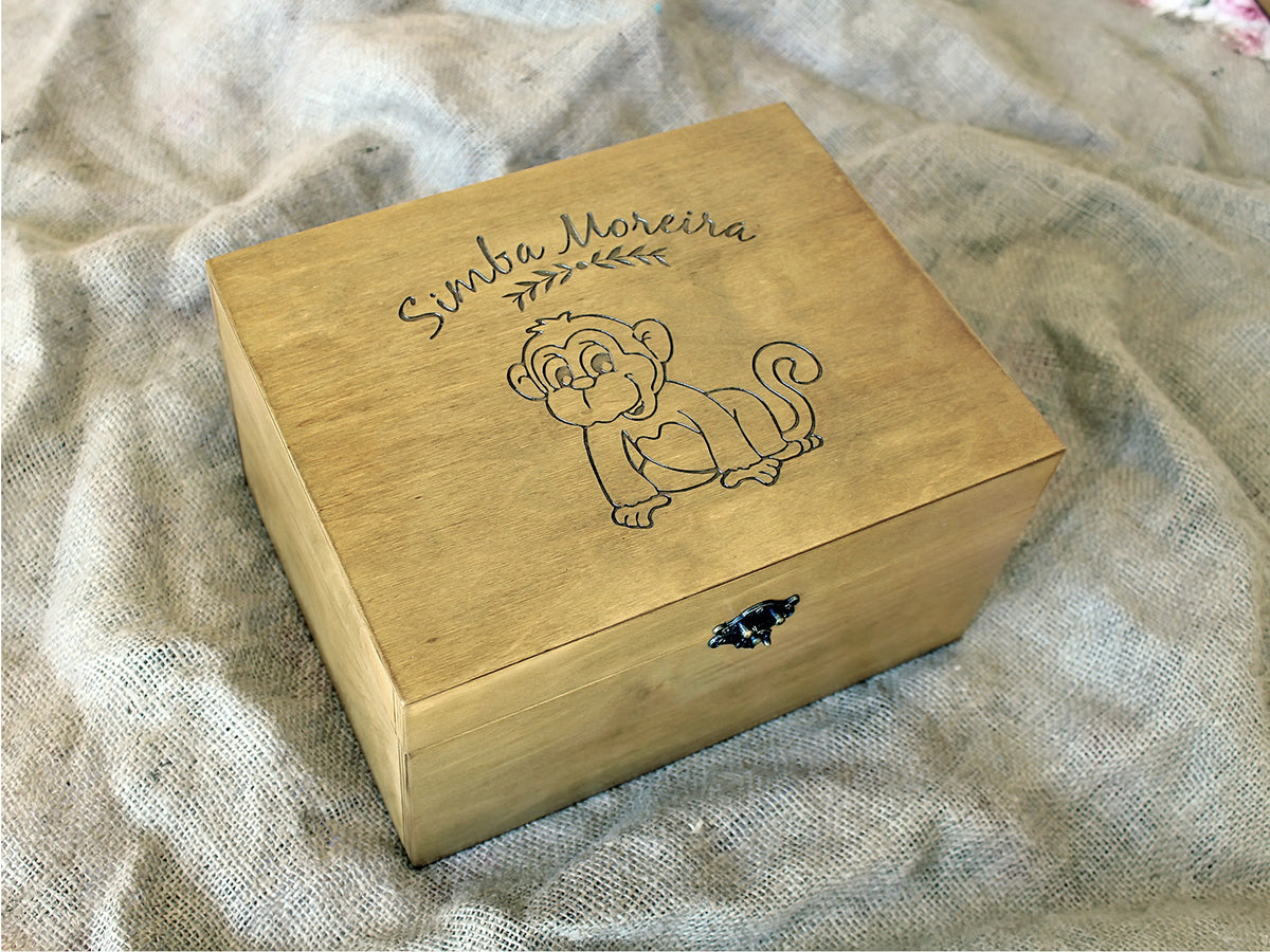 Wooden baby memory box with custom name and monkey engraving, photographed from an angle