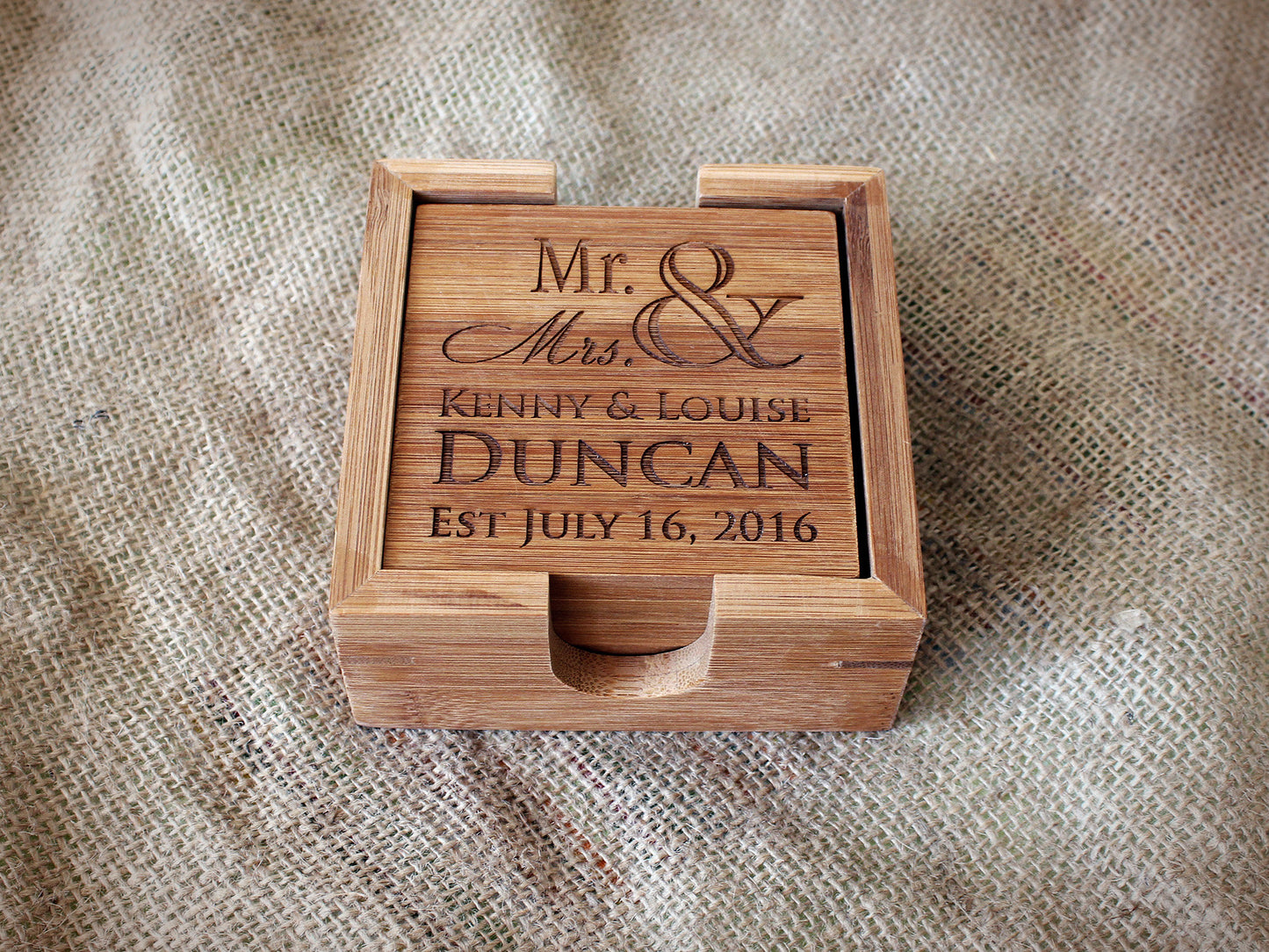 Personalized bamboo coaster set displayed in a matching bamboo holder