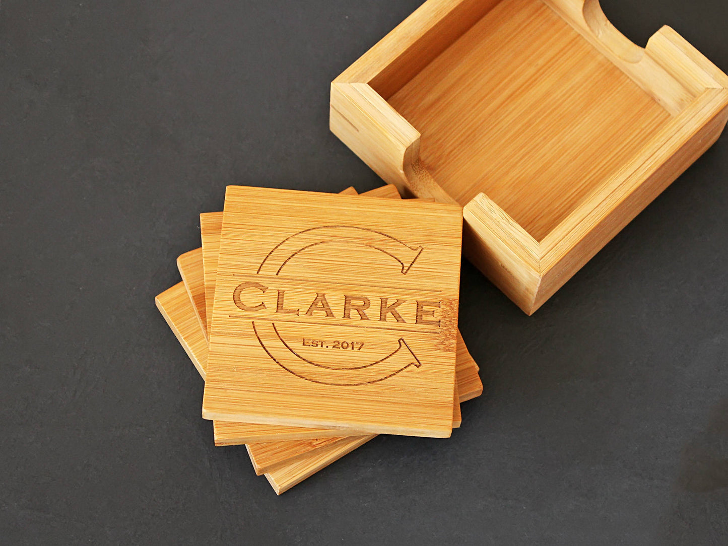 Personalized monogram bamboo coasters displayed on a coffee table