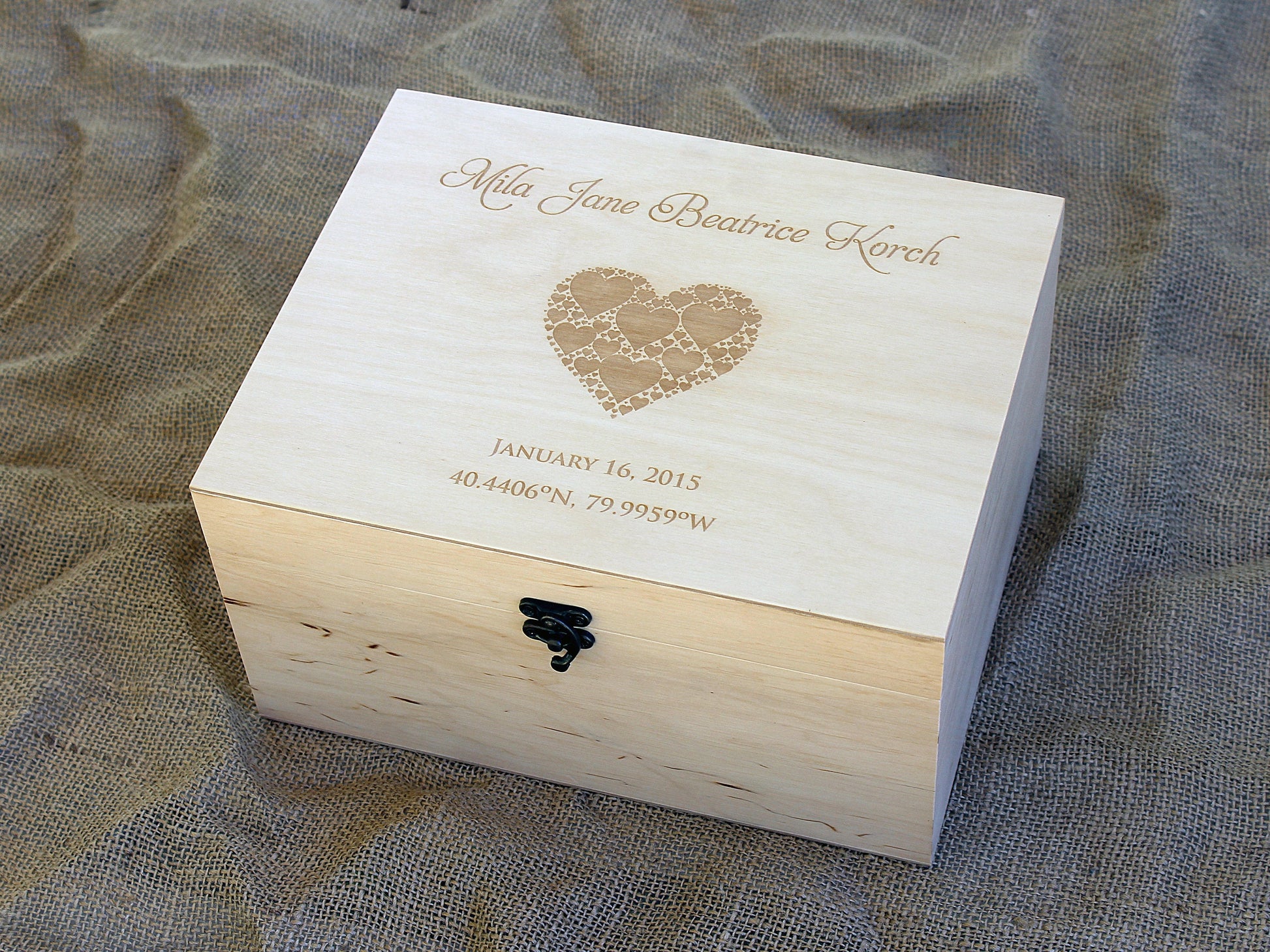 Side angle view of baby gift box with metal latch and clear varnish