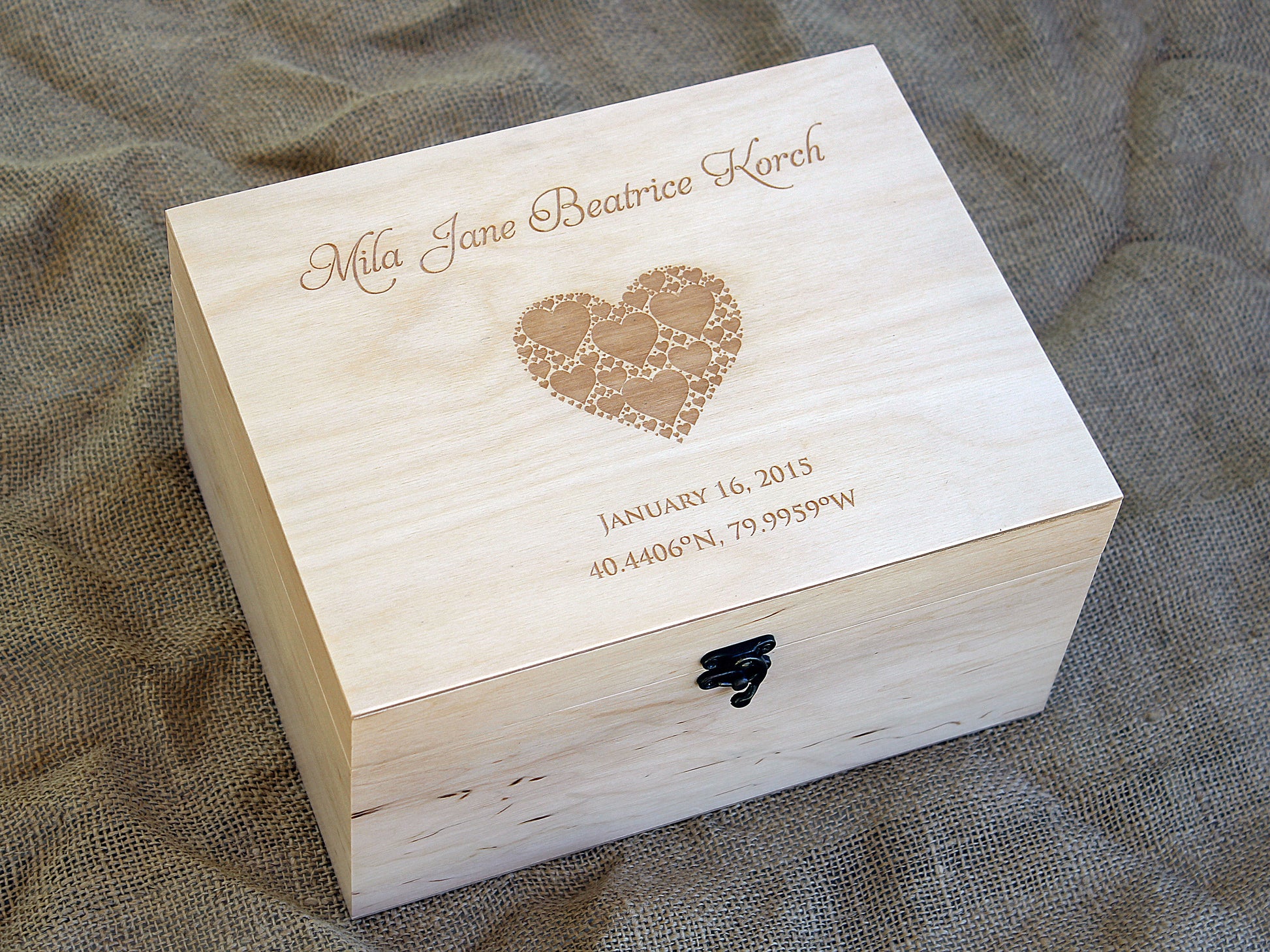 Side angle view of natural wood baby gift box with metal latch and smooth finish