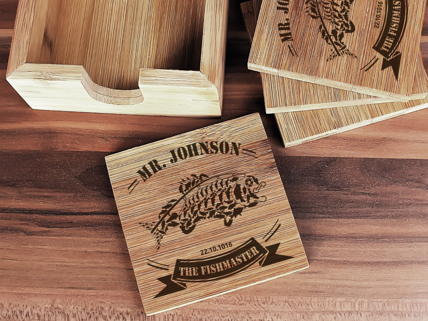 Four personalized bamboo coasters displayed with matching bamboo holder