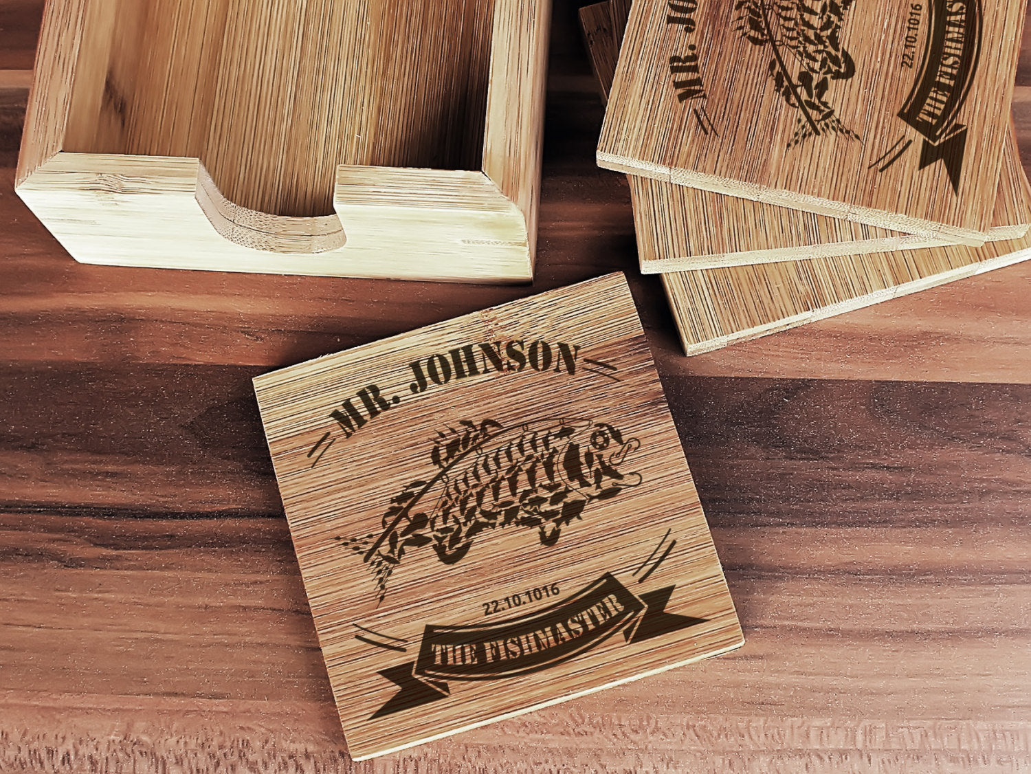 Four personalized bamboo coasters displayed with matching bamboo holder
